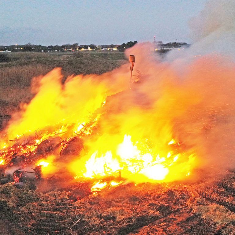 Eine Luftaufnahme eines Feuers, das auf einem Feld brennt.