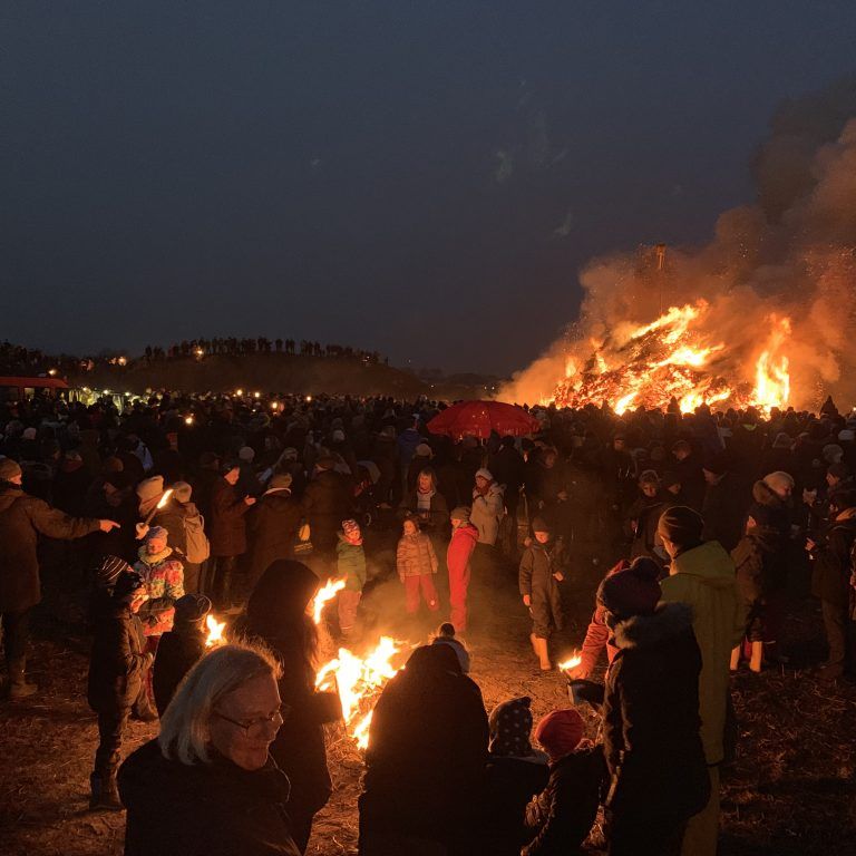 Eine große Gruppe Menschen versammelte sich um ein Lagerfeuer.